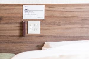 a bedroom with a bed and a light wooden wall at Super Hotel Nagoya Shinkansenguchi in Nagoya