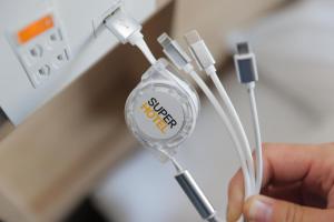 a person holding a usb cable in front of an outlet at Super Hotel Nagoya Shinkansenguchi in Nagoya