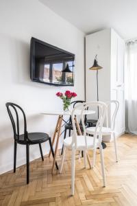 een eetkamer met zwarte en witte stoelen en een tafel bij New Studio in Fancy Neighborhood in Warschau