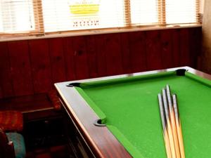 a green pool table in a room with a pool cue at Rooms at The Nook in Holmfirth