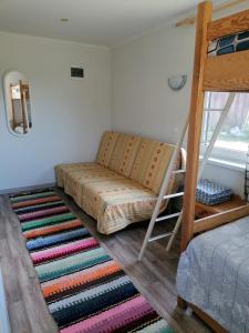 雲特史比斯的住宿－Saulespuķe，一间卧室配有双层床和地毯。