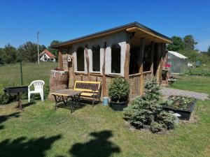 雲特史比斯的住宿－Saulespuķe，庭院中带桌子和长凳的凉亭