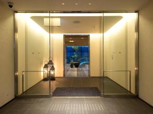 um corredor com uma porta de vidro que leva a um quarto em Hotel Forza Kyoto Shijo Kawaramachi em Quioto