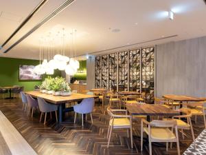 une salle à manger avec des tables et des chaises en bois dans l'établissement Hotel Forza Kyoto Shijo Kawaramachi, à Kyoto