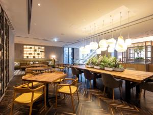 Un restaurante con mesas y sillas de madera y luces. en Hotel Forza Kyoto Shijo Kawaramachi, en Kioto