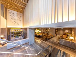 eine Lobby mit einer Treppe sowie Tischen und Stühlen in der Unterkunft Hotel Forza Kyoto Shijo Kawaramachi in Kyoto