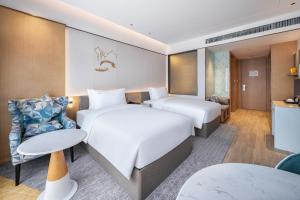 a hotel room with two beds and a table at Holiday Inn Tongren Wanshan, an IHG Hotel in Tongren