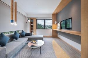ein Wohnzimmer mit einem Sofa und einem Tisch in der Unterkunft Holiday Inn Tongren Wanshan, an IHG Hotel in Tongren