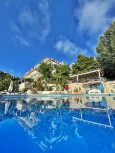 una gran piscina con una casa en el fondo en Hotel Garden Riviera, en Santa Maria di Castellabate