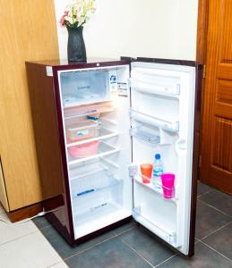 an empty refrigerator with its door open in a kitchen at Home and Away Cozy Studio Apartment number 407 in Nairobi