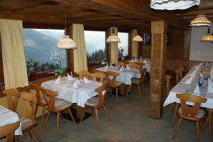a restaurant with tables and chairs with white tablecloths at Grindlalm in Zell am Ziller