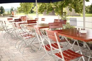um grupo de mesas e cadeiras sob um guarda-sol em Gasthaus zur Linde em Dombühl