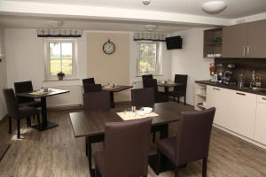 a dining room with tables and chairs and a kitchen at Gasthaus zur Linde in Dombühl