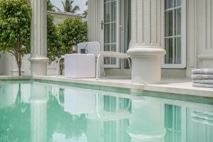a swimming pool with chairs and a house at MansionHaus in Anjuna