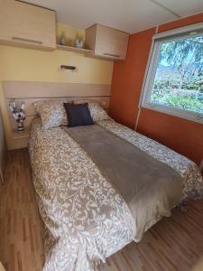 duże łóżko w sypialni z oknem w obiekcie Mobil-home Beau Rivage w mieście Gunsbach
