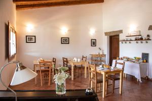 ein Esszimmer mit einem Tisch und Stühlen sowie ein Zimmer mit einem Tisch in der Unterkunft Locanda Rurale Lu Salconi in Bassacutena