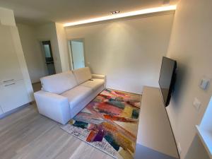 a living room with a white couch and a tv at Chaligne Suite in Aosta
