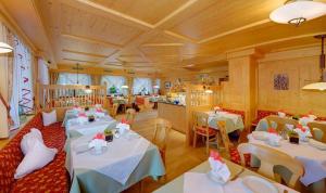 a restaurant with white tables and chairs and a room at Pension Brunhild in San Leonardo in Passiria