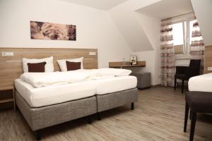 - une chambre avec 2 lits, une table et des chaises dans l'établissement Gasthaus zur Linde, à Dombühl