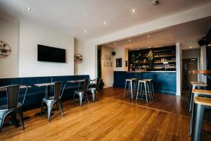 un bar con mesas y taburetes en un restaurante en Mordon Bar and Lodge en Newquay