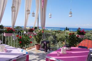 a table with a purple table cloth and flowers on a balcony at LUXURY TRADITIONAL ROOM The Small Bookstore in Kyllini