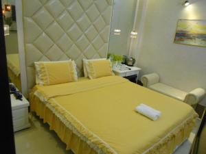 a bedroom with a large yellow bed with a large headboard at Thanh Hằng Homestay in Can Tho