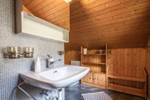 a bathroom with a white sink and wooden walls at Chalet Annabelle in Fiesch