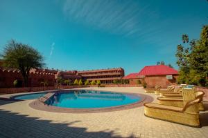 uma piscina com cadeiras e um edifício ao fundo em Puratan Qila em Sawai Madhopur