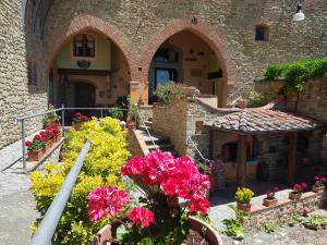 an outdoor garden with flowers in a building at Residence Le Santucce in Castiglion Fiorentino