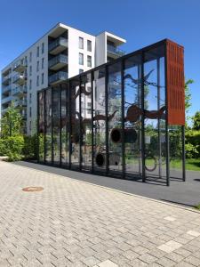 szklany budynek z budynkiem w tle w obiekcie Gdansk Apartament Harmonia Oliwska w Gdańsku