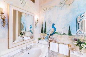 Baño con una pintura de pavos reales en la pared en Château La Creuzette, en Boussac