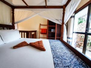 una camera con un letto con due cuscini sopra di Ebb & Flow a Paje
