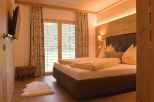 a bedroom with a large bed and a large window at Villa Alpin in Holzgau