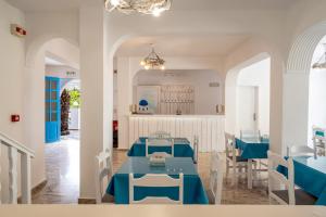una sala da pranzo con tavoli e sedie blu di Ikaros a Karterados
