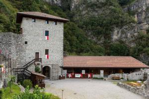 a large stone building in front of a mountain at Appartamento A 2 passi dal Lago Idro Lake in Bondone