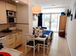 cocina y sala de estar con mesa y sillas en Estudio reformado cerca de la playa, AC, wifi, Neftlix, acepta mascotas, en Calpe