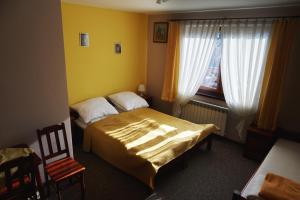 a bedroom with two beds and a chair and a window at Łapszańska Ostoja in Łapsze Niżne