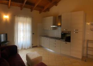 eine Küche mit weißen Schränken und einem Herd mit Backofen in der Unterkunft Villa Scati Apartments in Melazzo