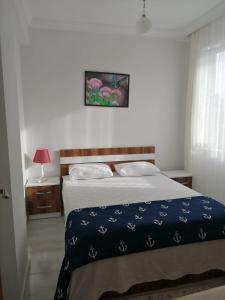 ein Schlafzimmer mit einem Bett mit einer blauen Decke in der Unterkunft Dalaman Airport Daltur Aparts in Dalaman