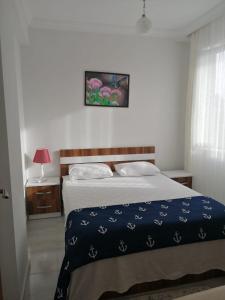 a bedroom with a bed with a blue blanket at Dalaman Airport Daltur Aparts in Dalaman