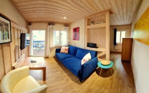 Una sala de estar con un sofá azul y una mesa. en Haus Abendsonne, en Stadt Wehlen