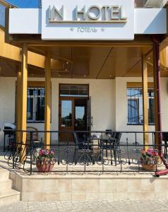 a hotel with chairs and tables in front of it at In hotel in Kamianets-Podilskyi