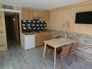 une cuisine avec une table et des chaises et une télévision dans l'établissement La Croisette, à Mont-de-Lans