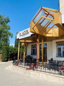 a restaurant with tables and chairs outside of a building at In hotel in Kamianets-Podilskyi