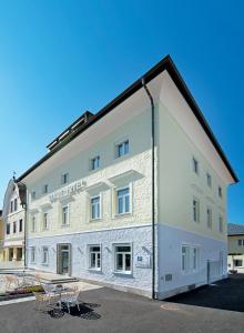 un edificio blanco con una mesa delante en Stadthotel Oberndorf - 24h Self Check-In Terminal en Oberndorf bei Salzburg