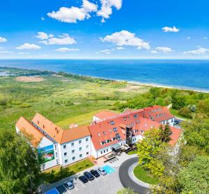 an aerial view of a building with the ocean in the background at Mona Lisa Wellness & Spa in Kołobrzeg