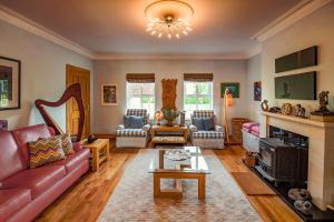 a living room with a red couch and a fireplace at Lynster House in Monaghan