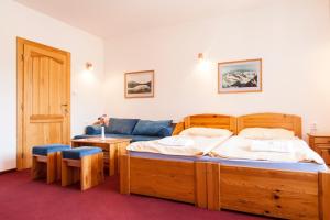 a bedroom with a bed and a blue couch at Penzion Snezienka in Tatranská Lomnica