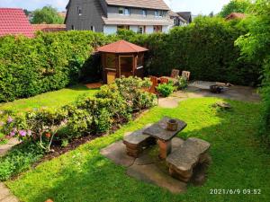 un jardín con mesa de picnic y cenador en Ferienhaus Marré - mit Grill, Feuerstelle und Gartensauna, en Waldbrunn