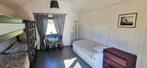 a small bedroom with a bed and a desk at Campsite Ģirti in Bernāti